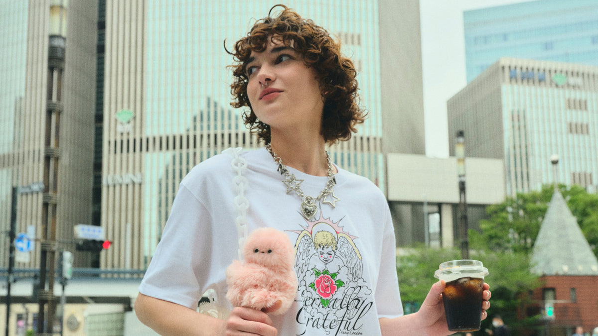 Person holding a Mirumi bag charm robot in a city street
